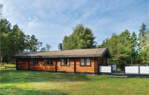 a log cabin in a field of grass with trees at 3 Bedroom Beautiful Home In lbk in Ålbæk