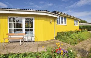 a yellow house with a table in front of it at Two-Bedroom Holiday Home In Broager in Broager
