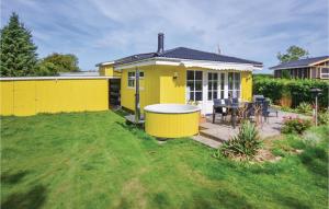 a yellow house with a table in the yard at Two-Bedroom Holiday Home In Broager in Broager