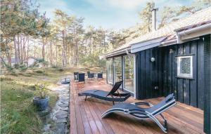 eine Holzterrasse mit Stühlen und ein Haus in der Unterkunft Four-Bedroom Holiday Home In Nexo in Vester Sømarken