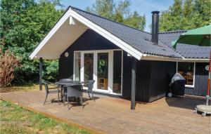 een zwart huis met een terras met een tafel en stoelen bij Amazing Home In Oksbl With Wifi in Oksbøl