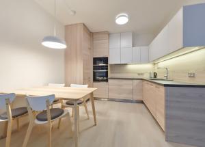 Residence Port Karolina في براغ: مطبخ مع طاولة وكراسي خشبية