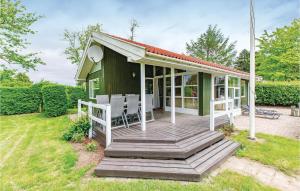 une petite maison verte avec une terrasse en bois dans l'établissement 3 Bedroom Beautiful Home In Fllenslev, à Føllenslev