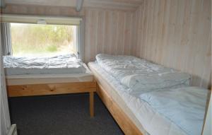 two beds in a room with a window at 4 Bedroom Pet Friendly Home In Ringkbing in Halkær