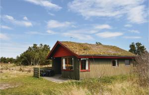 a small house with a grass roof on a field at Holiday Home Ringvejen Rømø Ix in Rømø