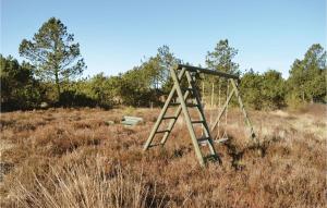 an old swing set in a field of tall grass at Holiday Home Ringvejen Rømø Ix in Rømø