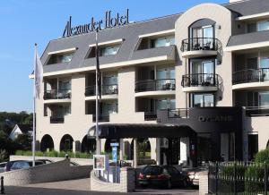 ein Hotelgebäude mit einem Parkplatz davor in der Unterkunft Alexander Hotel in Noordwijk aan Zee