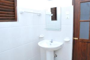 un bagno bianco con lavandino e specchio di Moonlit Bay Weligama a Weligama Altre 16 foto