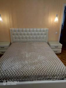 a bed in a room with two nightstands and a bed frame at Apartment on Zhaloytskaga 35 in Pinsk