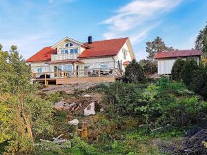 a large white house with a red roof on a hill at 10 person holiday home in KLÖVEDAL in Klövedal