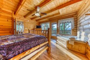 a log cabin bedroom with a bed and a ceiling fan at Kodiak #45 in Sevierville