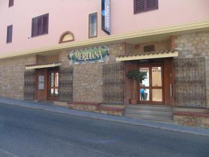 a building with a sign for a restaurant on a street at Hotel Meridiana in Arbus