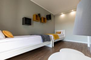 a bedroom with two beds and a tv on the wall at Amare Apartments A2 in Mosty