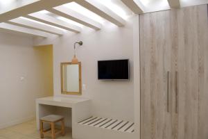 a room with a mirror and a tv on a wall at Blue Sky Hotel Apartments in Rethymno
