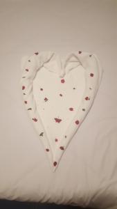 a white heart shaped pillow on a bed at Arena Relax Apartman in Belgrade