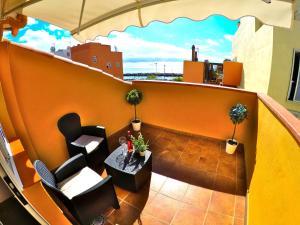 a balcony with two chairs and a table on a building at Apartamentos Ester in Santa Cruz de Tenerife