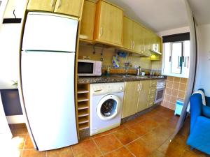 a kitchen with a refrigerator and a washing machine at Apartamentos Ester in Santa Cruz de Tenerife