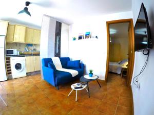 a living room with a blue couch and a table at Apartamentos Ester in Santa Cruz de Tenerife