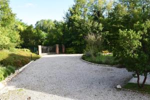 uma entrada de cascalho com um portão num parque em BeeHouse - La Casa delle Api Agriturismo em Borso del Grappa