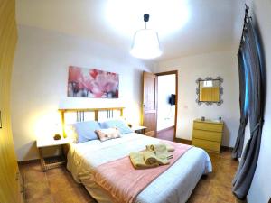 a bedroom with a large bed with a pink blanket at Apartamentos Ester in Santa Cruz de Tenerife