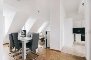 a dining room with a table and black chairs at Dill Apartment Frauenkirchenblick Dresden in Dresden