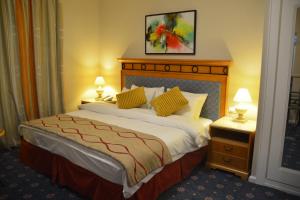 una camera d'albergo con un grande letto con due lampade di The Y Hotel ad Amman