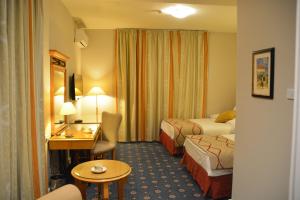 una camera d'albergo con 2 letti e una scrivania di The Y Hotel ad Amman