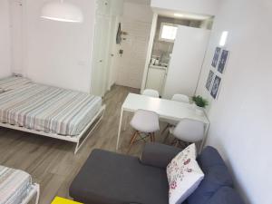 mały pokój z łóżkiem, stołem i kanapą w obiekcie New apartamento Jupiter w mieście Benalmádena
