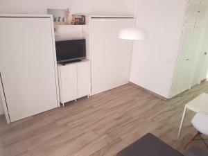 een woonkamer met witte kasten en een televisie bij New apartamento Jupiter in Benalmádena