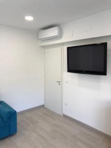 een woonkamer met een flatscreen-tv aan de muur bij Attico Lady D in Paola