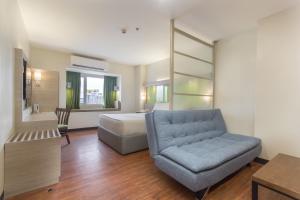 ein Schlafzimmer mit einem Bett, einem Sofa und einem Stuhl in der Unterkunft Microtel Inn & Suites by Wyndham San Fernando in San Fernando