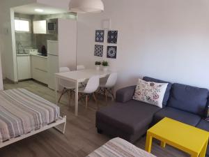 een woonkamer met een blauwe bank en een tafel bij New apartamento Jupiter in Benalmádena