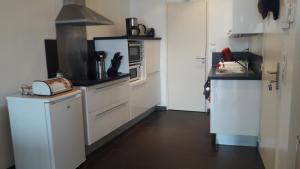 a kitchen with white cabinets and a microwave at appartement vue mer in Audierne