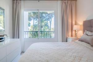 ミハスにあるMiraflores Apartmentのベッドと大きな窓のある寝室 +42枚の写真