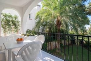 ミハスにあるMiraflores Apartmentのヤシの木のあるバルコニー(テーブル、椅子付)