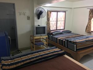 桐艾的住宿－Orchid Guest House，一间卧室设有两张床、一台电视和一扇窗户。