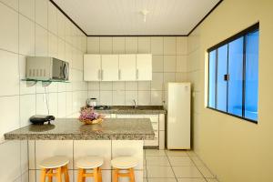 a kitchen with three stools and a counter top at Resid.l Canto do Encanto in Garopaba