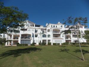 ein großes weißes Gebäude mit einem Hof davor in der Unterkunft Hacienda Riquelme Golf Resort, Atlantico 188, Ground Floor Apartment in Sucina