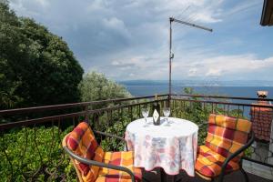 stół i krzesła na balkonie z widokiem na ocean w obiekcie Vacation home, Ferienhaus KLAUDIA in Kraj, Mošćenička Draga near Opatija w mieście Mošćenička Draga