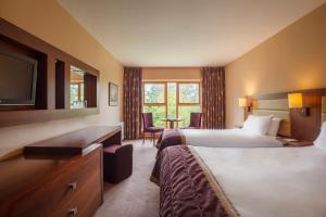 a hotel room with two beds and a television at Westport Woods Hotel & Spa in Westport