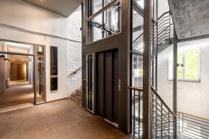 an open hallway with glass doors and a staircase at YoHo - The Young Hotel in Hamburg