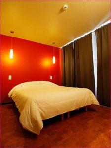スタヴロにある ホテル O マル エメの赤い壁のベッドルーム1室(白いベッド1台付)