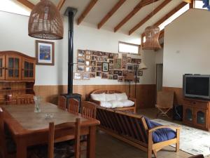a living room with a table and a wood stove at Gran casa en Isla Negra in Isla Negra