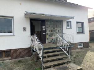 a white house with a staircase leading to the front door at Apartment Ground Floor Laatzen in Hannover