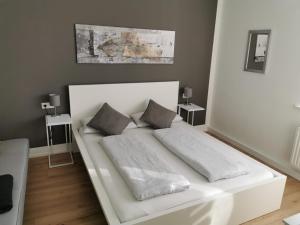 フリードリヒスハーフェンにあるApartment Friedrichshafen Centerの白いベッド(枕2つ付)が備わる客室です。