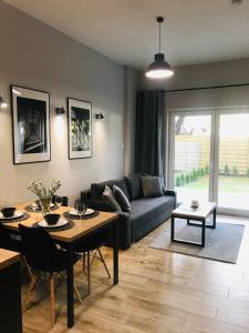 ein Wohnzimmer mit einem Sofa und einem Tisch in der Unterkunft Property Apart - Soft Lofty Legnicka Centrum in Breslau