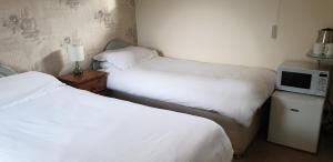 A bed or beds in a room at Beoley Lodge 