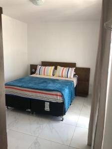 um quarto com uma cama com um cobertor azul em Porto Cavalinho apartamento 10 em Porto de Galinhas