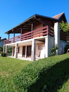 a house on a hill with a green lawn at Jana in Bukovac