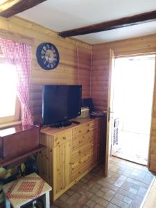 a living room with a television and a clock on the wall at Jana in Bukovac